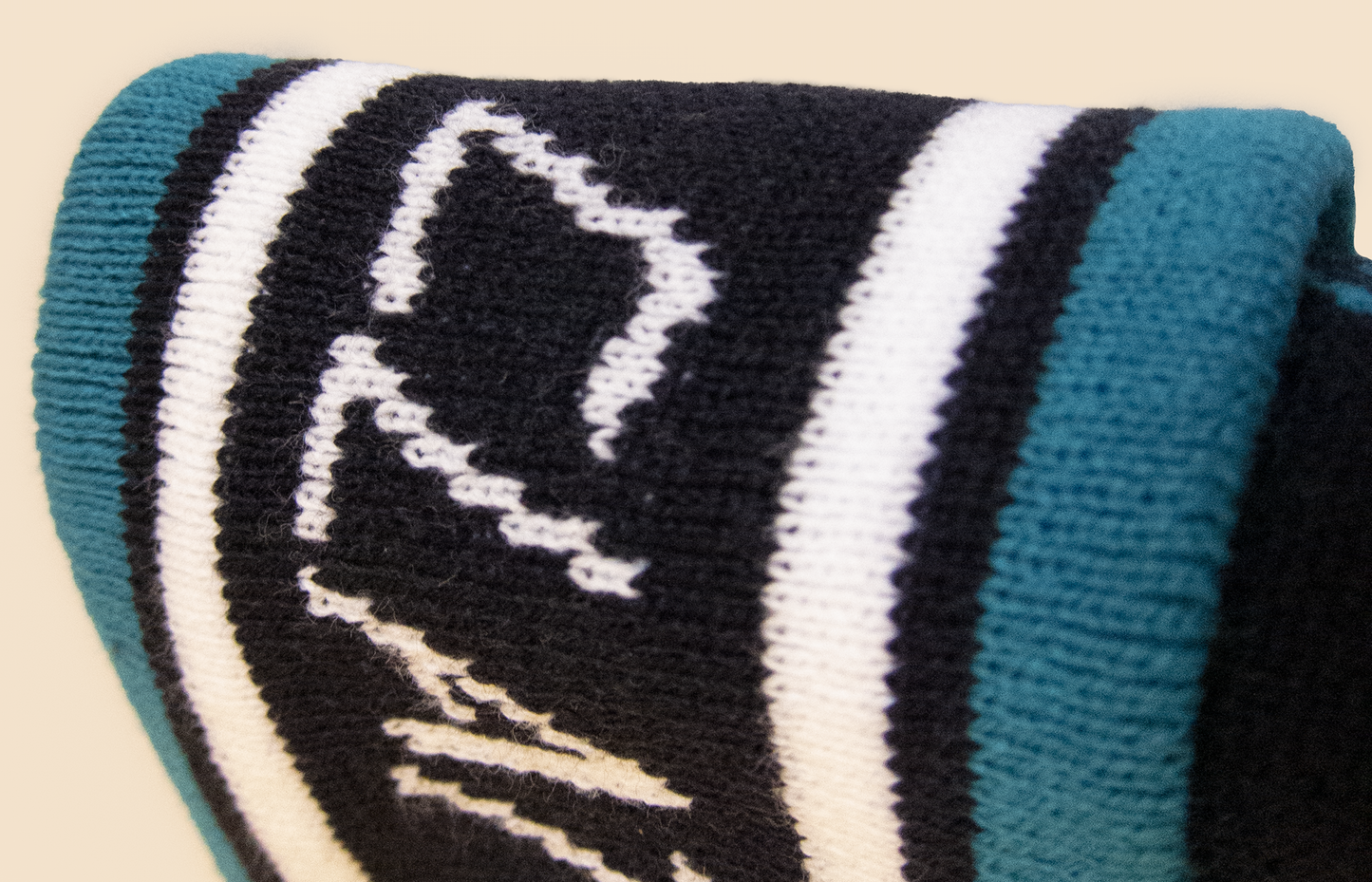 Close-up of a knitted product with a logo on a beige background
